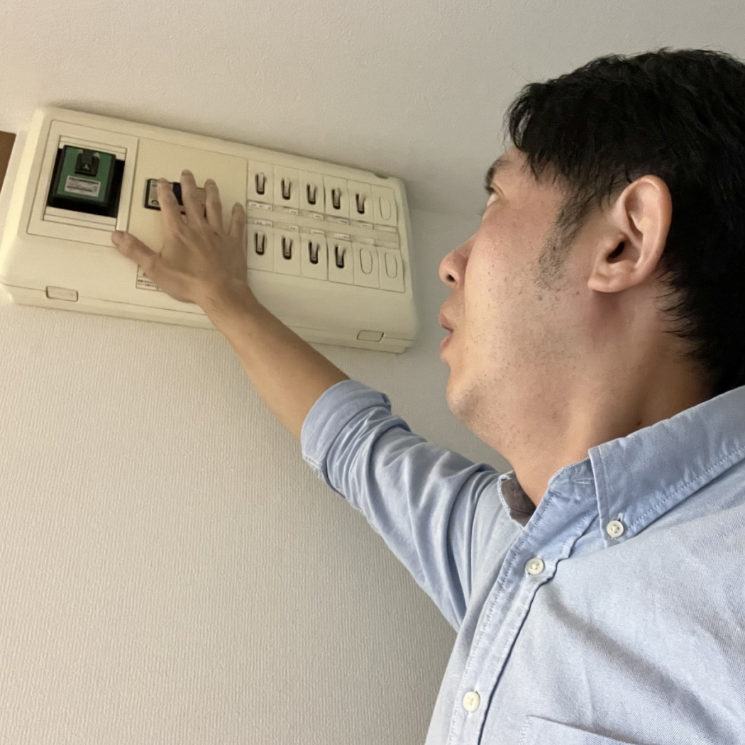 落ちたブレカーを戻す男性